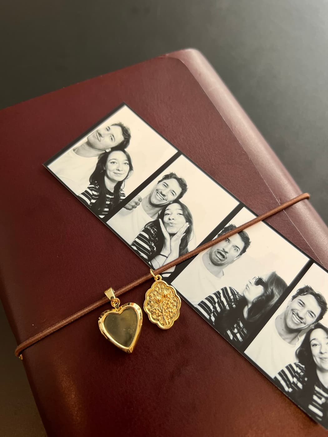 Een doorleefde wijnrode journal met patina, fotostrip en gouden bedels